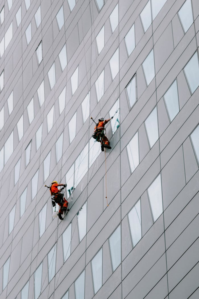 home-services-02 High-rise facade window cleaning on a modern skyscraper for urban maintenance.